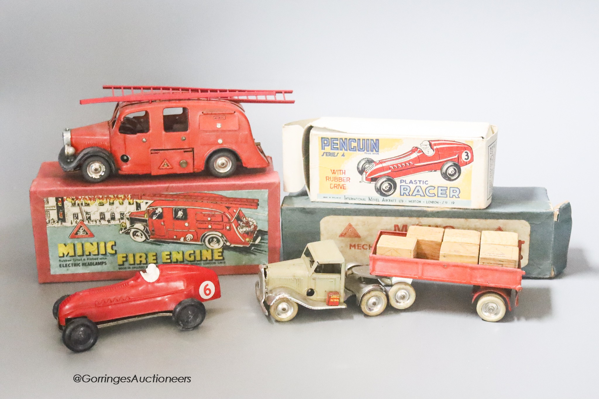 A Tri-ang Minic pre-war mechanical horse and tractor, a Tri-ang Minic fire engine and a penguin racer, boxed